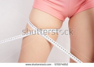 stock-photo-woman-measuring-thigh-with-tape-570574852